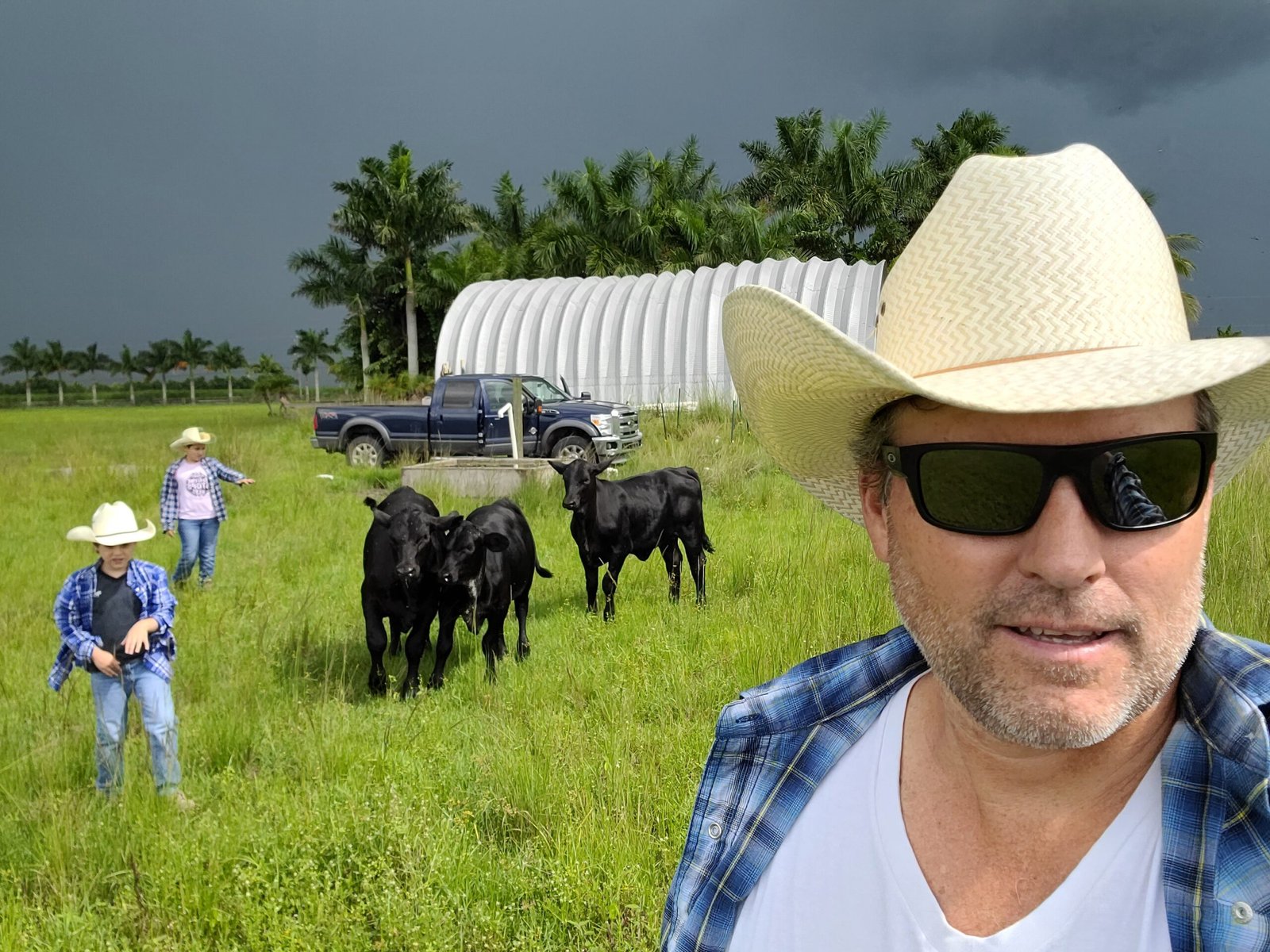 Gregory Keough with his family and Brangus cattle on the ranch